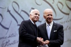 FILE - Sen. John McCain, R-Ariz., receives the Liberty Medal from the Chair of the National Constitution Center's Board of Trustees, former Vice President Joe Biden, in Philadelphia, Oct. 16, 2017.