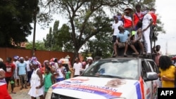 FILE - Supporters of the New Patriotic Party cheer on the street after President Nana Akufo-Addo filed his nomination forms for the 2020 presidential election at the Electoral Commission Head Office in Accra, Ghana, Oct. 6, 2020.