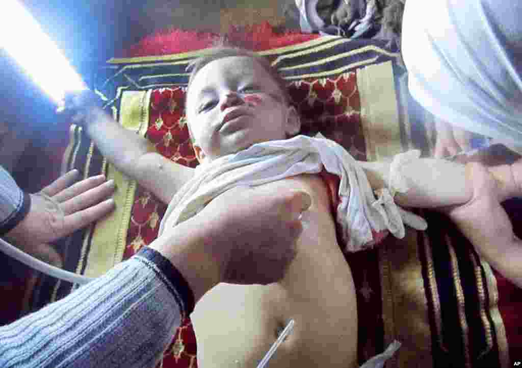 A Syrian doctor treats an infant, injured by government forces shelling, at Baba Amr neighborhood in Homs province.(AP/Local Coordination Committees in Syria) (The Associated Press cannot independently verify the content, date, location or authenticity of