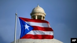 The Puerto Rican flag flies in front of Puerto Rico’s Capitol in San Juan, July 29, 2015. 