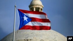 The Puerto Rican flag flies in front of Puerto Rico’s Capitol in San Juan, July 29, 2015. 