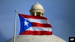 La bandera de Puerto Rico ondea sobre el edificio del Capitolio en San Juan, donde los legisladores no otorgaron fondos para el pago de la deuda.