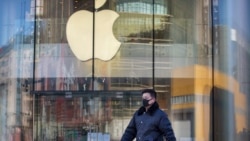 A man wears a face mask as he walks past an Apple store that is temporarily closed due to health concerns in Beijing, Tuesday, Feb. 4, 2020. Apple announced that it will temporarily close all of its stores in China due to a virus outbreak. (AP Photo/Mark