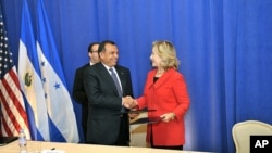 U.S. Secretary of State, Hillary Clinton, and Honduran President, Porfidio Lobo, sign BRIDGE.