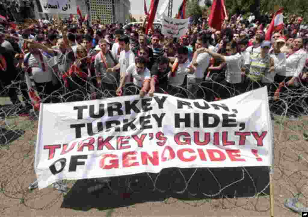 Lebanese Armenian protesters set on the barbed wire a banner against Turkey during a protest to mark the 97th anniversary of massacres in Turkey that began in April 1915 and in which hundreds of thousands of Armenians died, in front the Turkish embassy, i