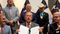 Texas Gov Greg Abbott shows off his signature after signing Senate Bill 1, also known as the election integrity bill, into law in Tyler, Texas, Sept. 7, 2021. 