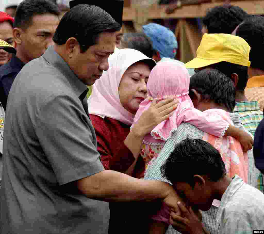 Ibu Ani Yudhoyono memeluk seorang anak prempuan di Banda Aceh setelah bencana gempa dan tsunami yang melanda Aceh, 19 Februari 2005. (Foto: Tarmizi Harva/Reuters)