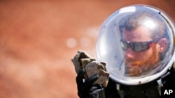 Florian Commans, crew biologist and greenhab officer, of Crew 153, studies a collection of rocks near the Mars Desert Research Station, in Hanksville, Utah, April 18, 2015. 