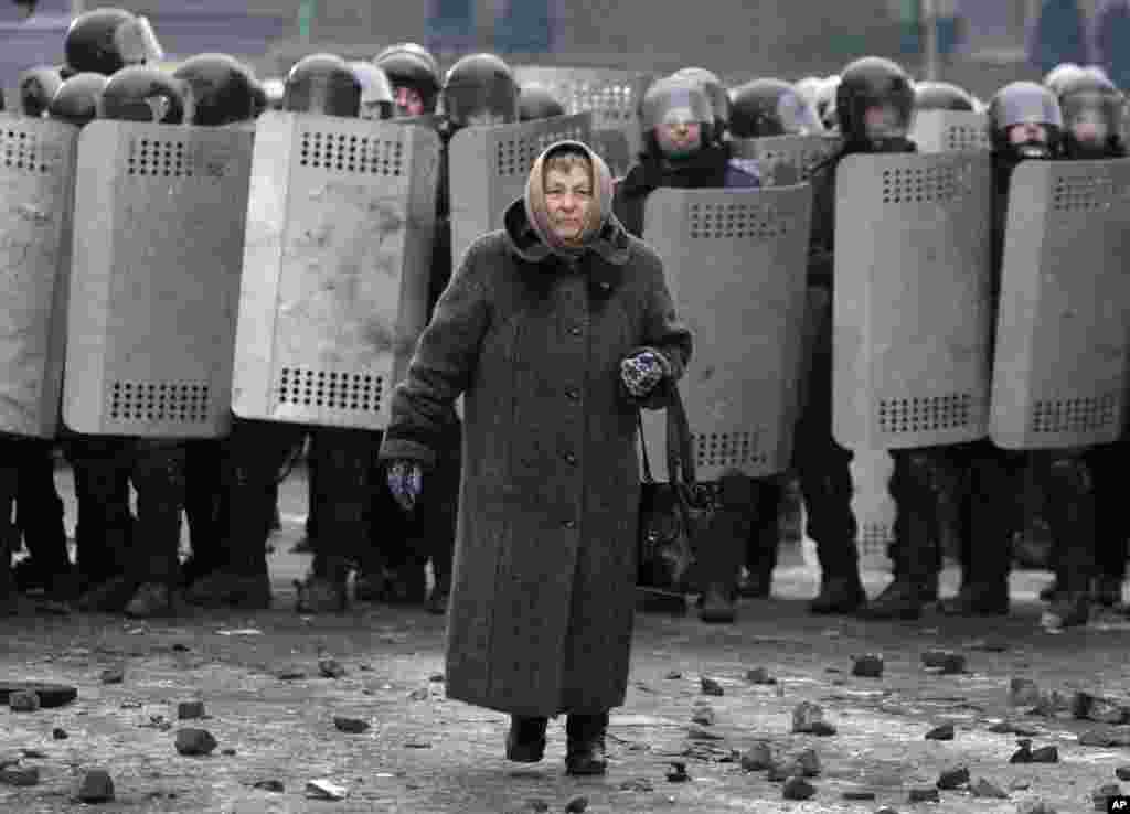 Uma mulher afasta-se do bloqueio policial numa rua no centro de Kiev, Jan. 21, 2014.