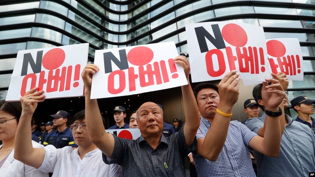 South Korean protesters hold up cards during a rally against Japan in front of a building that houses the Japanese embassy in Seoul, South Korea, Aug. 2, 2019. The signs read " Japanese Prime Minister Shinzo Abe."