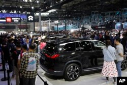 Pengunjung menyaksikan mobil jenis SUV bertenaga listrik yang diproduksi oleh pembuat mobil China NIO selama China Auto Show di Beijing. (Foto: AP)