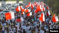 Protesters holding Bahraini flags march during anti-government protest organised by country's Al Wefaq opposition party, Budaiya, west of Manama, June 6, 2014.