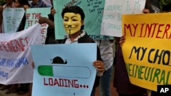 FILE - An activist wears a mask as he holds a placard during a demonstration supporting net neutrality, in Bangalore, India, .