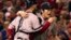 El lanzador relevista Koji Uehara es abrazado por su cátcher, David Ross, luego de que los Medias Rojas ganaran el quinto juego de la Serie Mundial de béisbol.