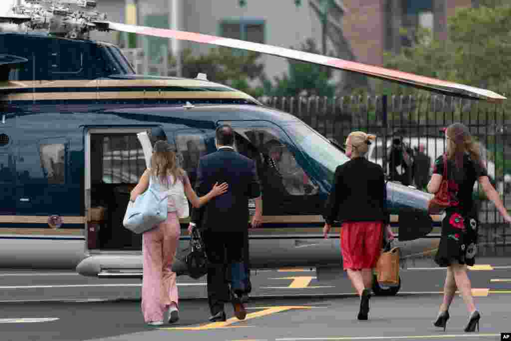 New York Governor Andrew Cuomo and others walk toward a helicopter at a Manhattan heliport. Cuomo announced his resignation over a barrage of sexual harassment allegations as momentum built in the state legislature to remove him by impeachment.