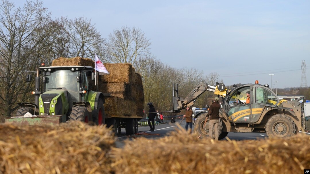 Agricultores instalan fardos de heno en una carretera cerca del aeropuerto principal de París, el lunes 29 de enero de 2024, cerca de Roissy-en-France, al norte de París.