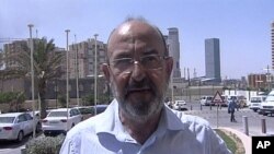 In this image made from television, Italian journalist Claudio Monici of Avvenire, the daily of the Italian bishops conference, speaks to reporters in Tripoli, Libya, Aug. 25, 2011, after his release