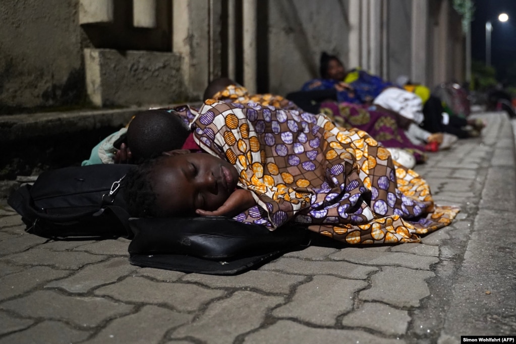 Des évacués de la ville de Goma ont passé la nuit dans une rue près de la frontière entre la RDC et le Rwanda à Gisenyi, au Rwanda, le 23 mai 2021.