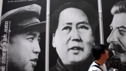 資料照片：在首爾一家韓戰展覽館，遊人走過戰時三名共產黨領袖金日成、毛澤東和斯大林的像。 (2010年5月21日)