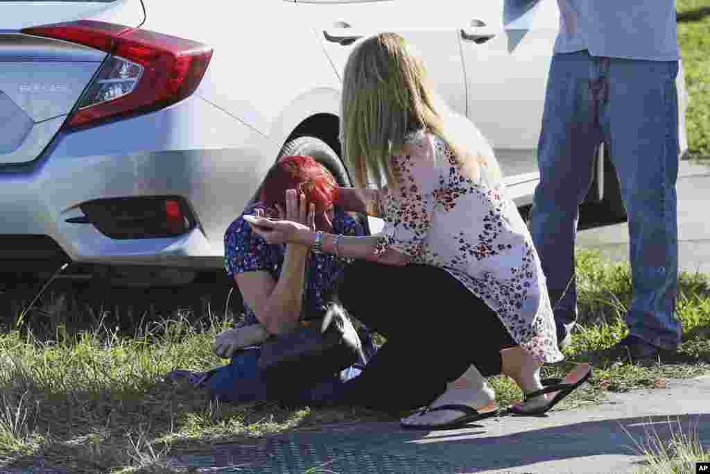 A woman consoles another at Marjory Stoneman Douglas High School in Parkland, Feb. 14, 2018.