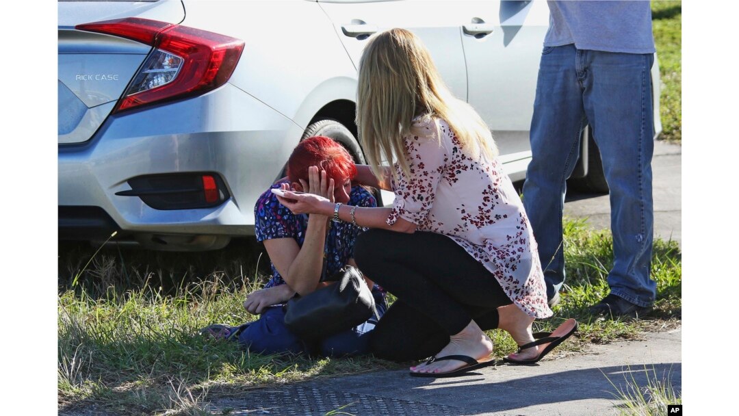 A woman consoles another as parents wait for news regarding a shooting at Marjory Stoneman Douglas High School in Parkland, Fla., Feb. 14, 2018.