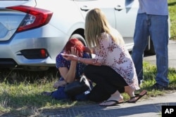 A woman consoles another as parents wait for news regarding a shooting at Marjory Stoneman Douglas High School in Parkland, Fla., Feb. 14, 2018.