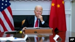 President Joe Biden listens as he meets virtually with Chinese President Xi Jinping from the Roosevelt Room of the White House in Washington, Nov. 15, 2021. 