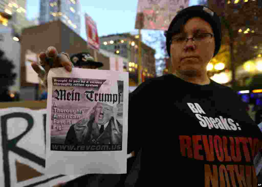 A protester holds a sign with a derogatory image of President-elect Donald Trump during a protest, in downtown Seattle, Nov. 9, 2016.