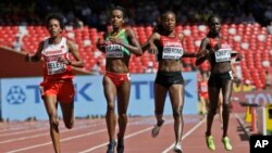 De gauche à droite, Mimi Belete du Bahreï, Genzebe Dibaba de l'Éthiopie, Mercy Cherono du Kenya, et Irene Chepet Cheptai du Kenya, disputent la première manche des 5000 m féminins aux championnats mondiaux d'athlétisme au stade Bird's Nest de Pékin, 27 ao