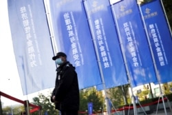 FILE - A security guard stands outside the venue of the Financial Street Forum annual conference in Beijing, China, Oct. 20, 2021.