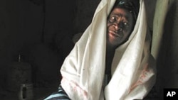 Former circumciser Mariam Coulibaly displays the tools of her trade, a knife handed down to her by her mother and herbs to heal the wounds, at her home in Salemata, southeastern Senegal (2003 file photo)