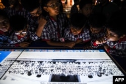 Murid-murid India dari Kendriya Vidyalaya di Dwarka memperhatikan foto-foto interaktif berbagai kabinet politik yang merupakan salah satu koleksi yang dipamerkan di Museum President’s House di New Delhi, 29 Agustus 2018.