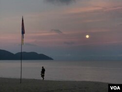 The sun sets on the beach in Penang, where one citizen jumped into the sea to avoid arrest for violating Malaysia’s virus lockdown order.