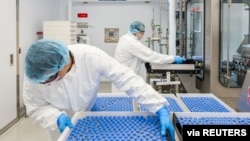 Lab technicians load vials of investigational coronavirus disease (COVID-19) treatment drug Remdesivir at a Gilead Sciences facility in La Verne, California, March 18, 2020. (Gilead Sciences Inc/Handout)