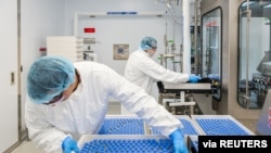 FILE - Lab technicians load vials of investigational coronavirus disease (COVID-19) treatment drug remdesivir at a Gilead Sciences facility in La Verne, California, March 18, 2020. (Gilead Sciences)