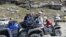People sit on their all terrain vehicles at Rohtang Pass, India, Sept. 20, 2013. (Anjana Pasricha for VOA) 