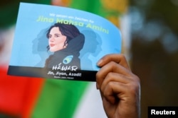 FILE - A demonstrator holds a poster during a protest following the death of Mahsa Amini in Iran, in Berlin, Germany, October, 22, 2022. (REUTERS/Christian Mang)