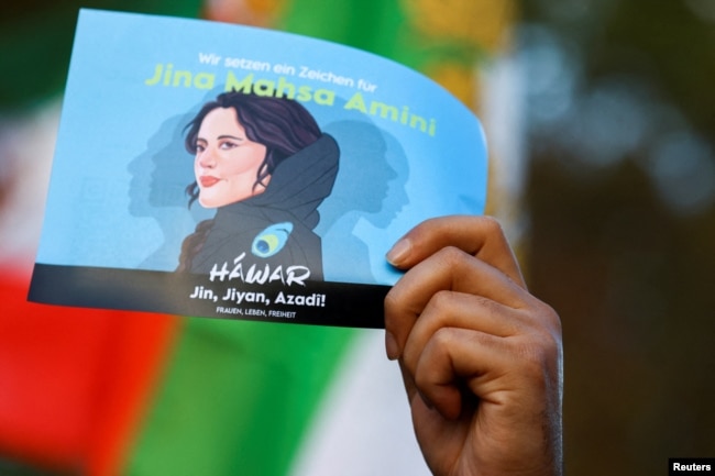 FILE - A demonstrator holds a poster during a protest following the death of Mahsa Amini in Iran, in Berlin, Germany, October, 22, 2022. (REUTERS/Christian Mang)