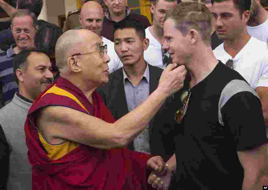 Tibetan spiritual leader the Dalai Lama holds the chin of the Australian cricket team captain Steven Smith during an interaction with the team at the Tsuglakhang temple in Dharmsala, India.