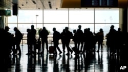 FILE - In this Wednesday, March 17, 2021 file photo, travelers walk through the Salt Lake City International Airport in Salt Lake City. On Sunday, March 21, more than 1.5 million people streamed through U.S. airport security checkpoints, the largest…