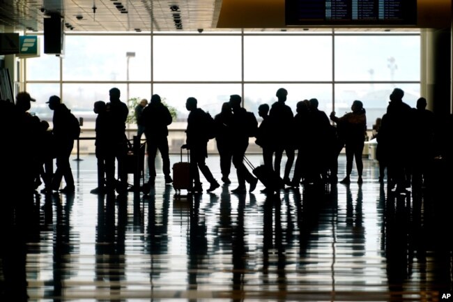 Wisatawan berjalan melalui Bandara Internasional Salt Lake City di Salt Lake City pada hari Minggu, 21 Maret. (Foto: AP)