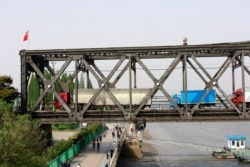 FILE - Trucks wait for border inspection at the Chinese end of the Friendship Bridge that connects Sinuiju, North Korea, with Dandong, Liaoning province, China, over the Yalu River, May 24, 2018.
