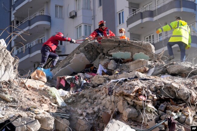 Tim SAR mencari orang di reruntuhan bangunan yang hancur di Adana, Turki selatan, Selasa, 7 Februari 2023. (Foto: AP)