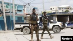 Dua orang polisi tampak berjaga-jaga di dekat Hotel Hayat, lokasi terjadinya serangan militan bersenjata kelompok al-Shabaab yang terkait dengan Al Qaeda, di Mogadishu, Minggu (21/8). 