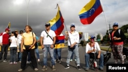 Opposition supporters wave Venezuelan national flags while blocking a highway to protest President Nicolas Maduro's government, in Caracas, May 15, 2017.