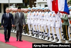 Sekretaris Dewan Keamanan Rusia Sergei Shoigu dan Menteri Pertahanan Sjafrie Sjamsoeddin memeriksa pasukan kehormatan dalam upacara penyambutan di Jakarta, 25 Februari 2025. (Foto: Ajeng Dinar Ulfiana/Reuters)