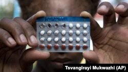 A woman holds a packet of contraceptive pills, in Harare, Thursday, April 9, 2020. Lockdowns imposed to curb the coronavirus’ spread have put millions of women in Africa, Asia and elsewhere out of reach of birth control and other health needs. (AP Photo/Tsvangirayi Mukwazhi)