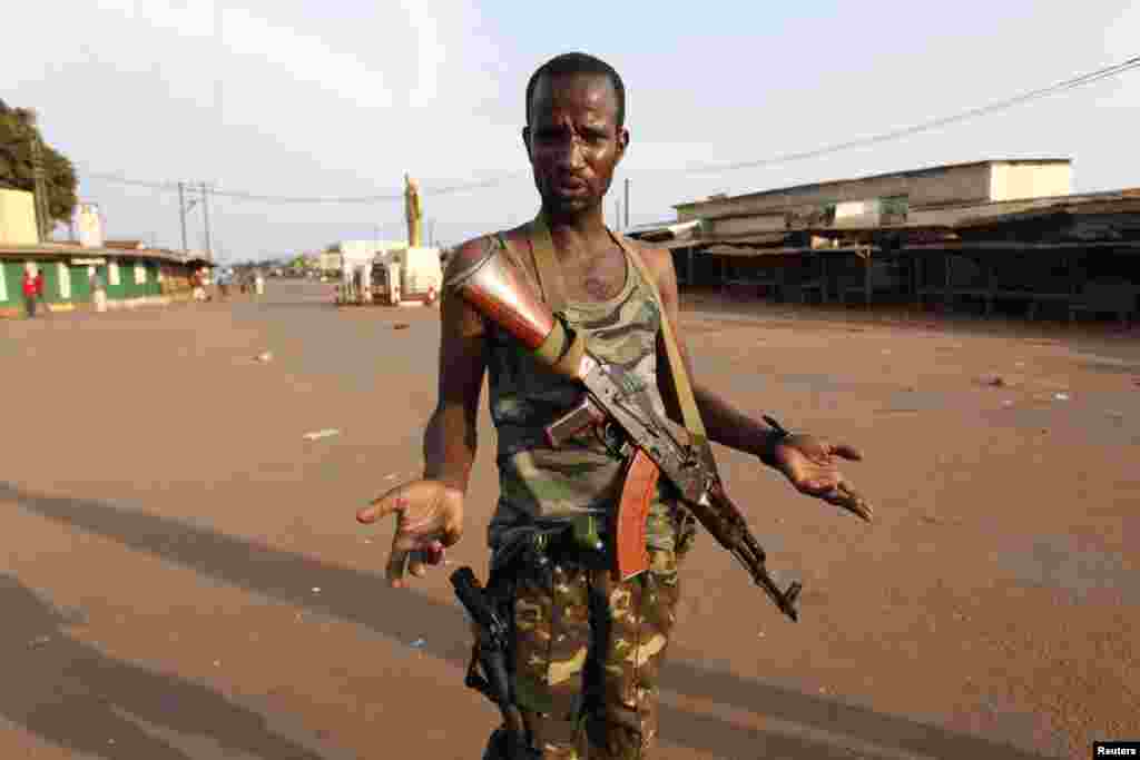 A Seleka fighter gestures outside a mosque where bodies of people killed during fighting are gathered in Bangui, Central African Republic, Dec. 5, 2013.