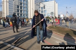 Učesnik protesta čisti učicu nakon sinoćnjeg masovnog skupa u Novom Sadu, drugoga dana protesta u tom gradu i blokade Mosta slobode, 2. februara 2024. (Foto: FoNet)