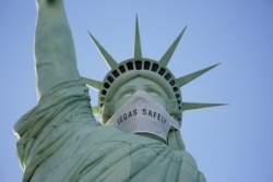 An oversized mask adorns the face of a replica Statue of Liberty at the New York-New York hotel and casino July 16, 2020, in Las Vegas.